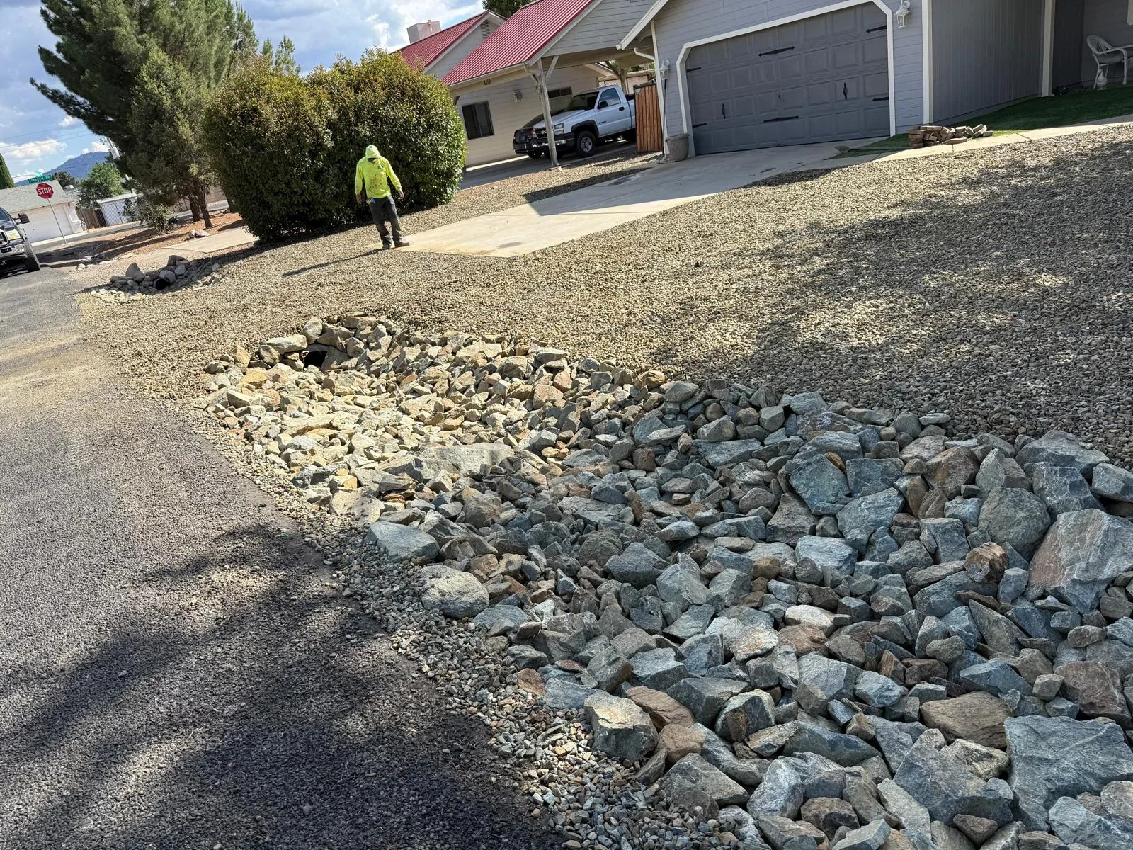 Residential driveway with decorative rock edging and gravel installation in Prescott Valley