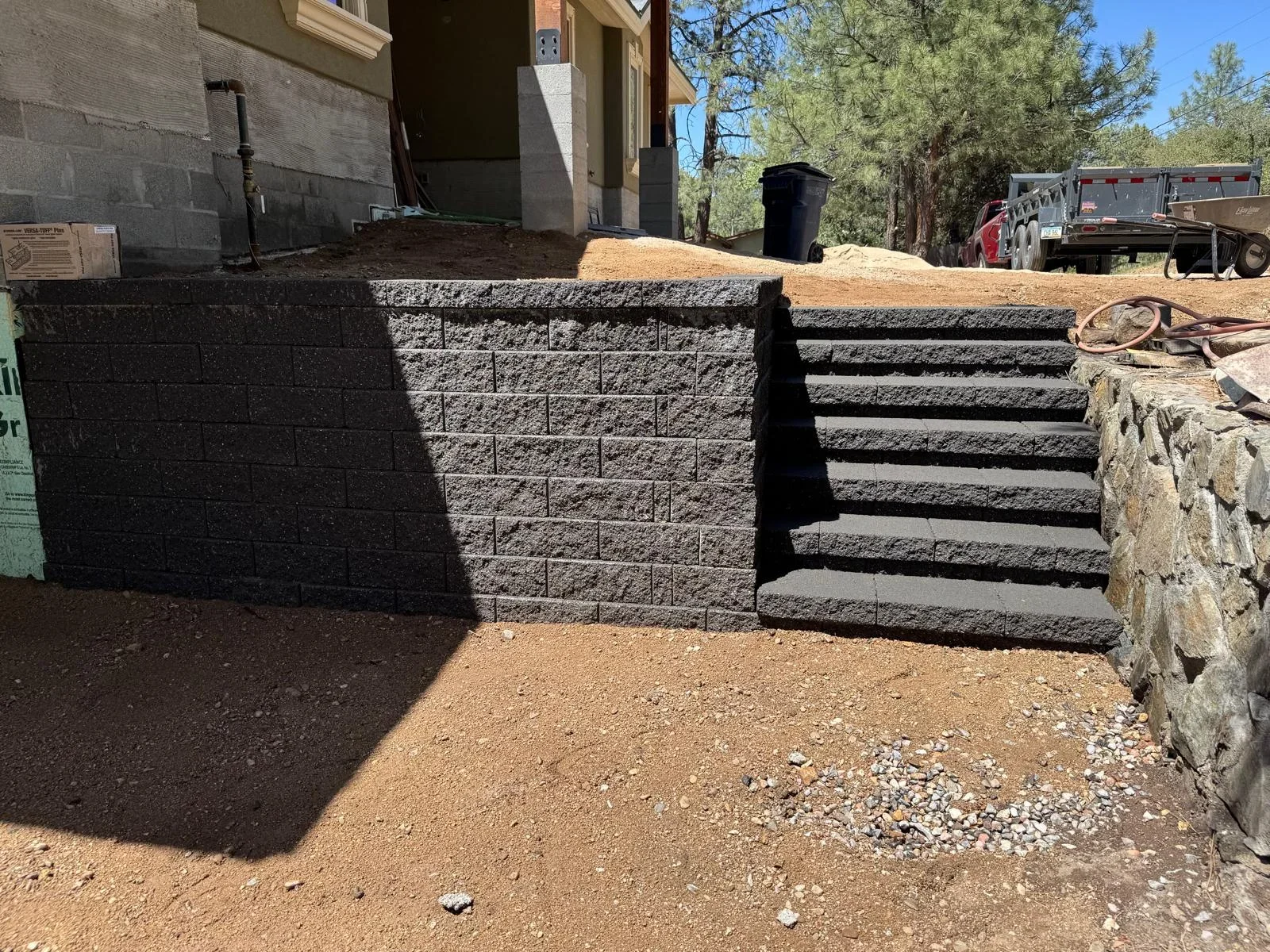 Gray concrete block retaining wall with stepped entry stairs on residential property