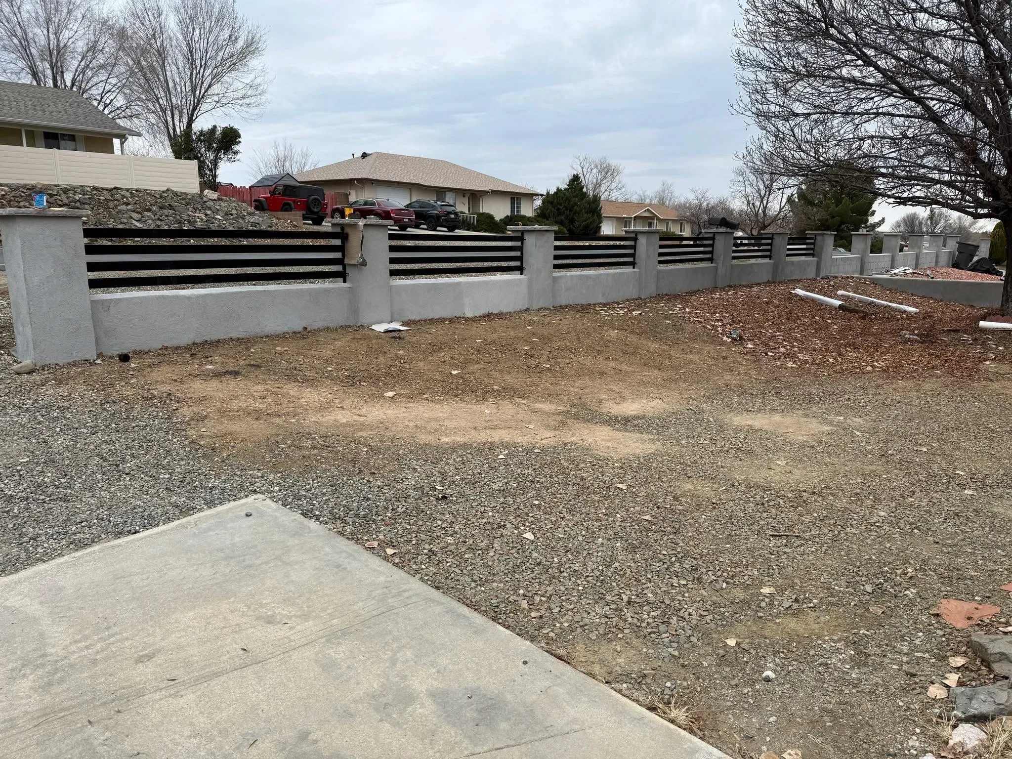 Concrete retaining wall with black metal railing panels and gravel landscape in Prescott Valley