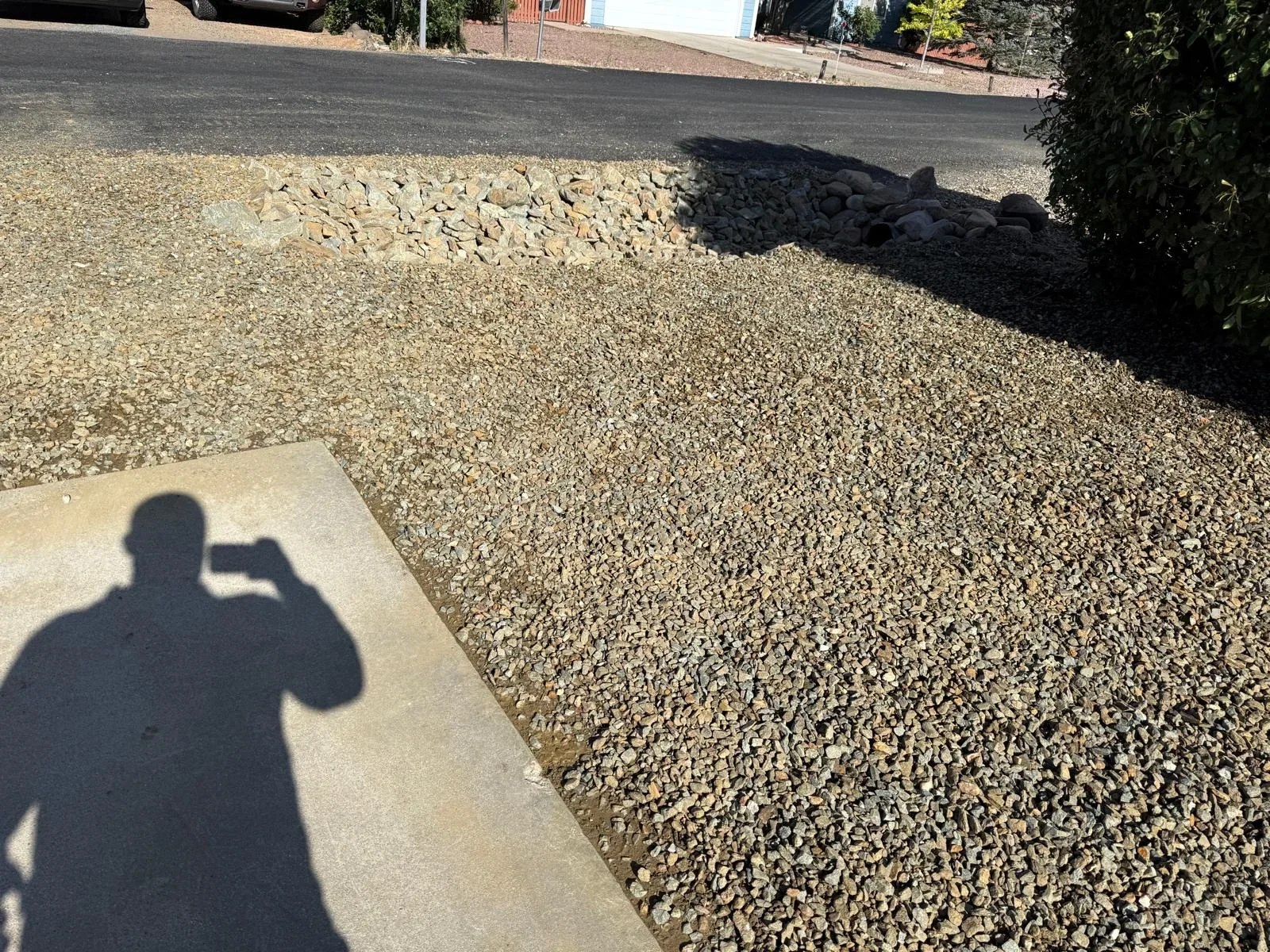 Newly installed gravel driveway with river rock edging and compacted base material
