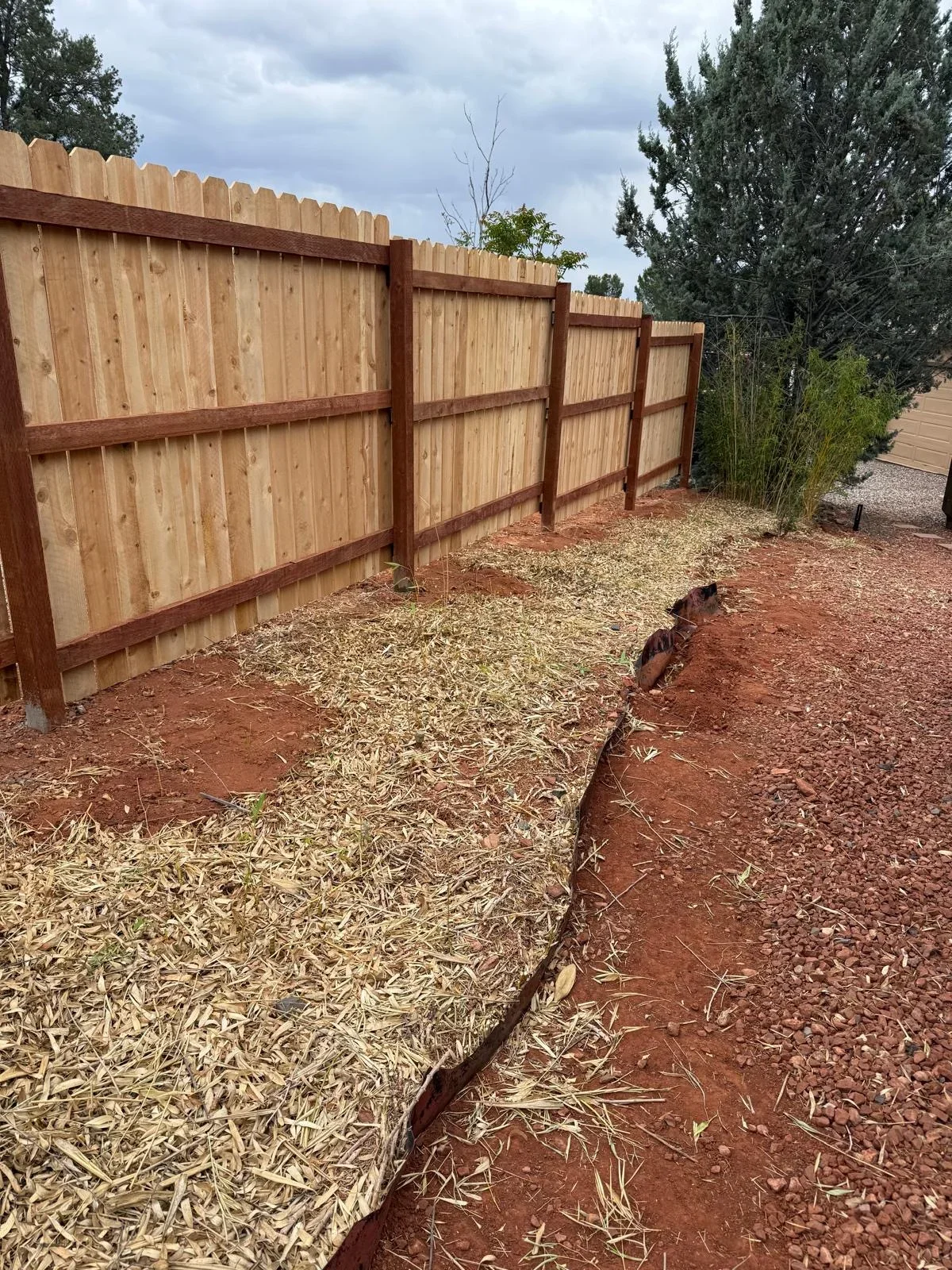 Cedar privacy fence with stained posts and gravel landscaping in Prescott Valley